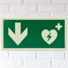 defibrillator aed hinweisschild mit pfeil nach unten bzw hinten langnachleuchtend beispiel