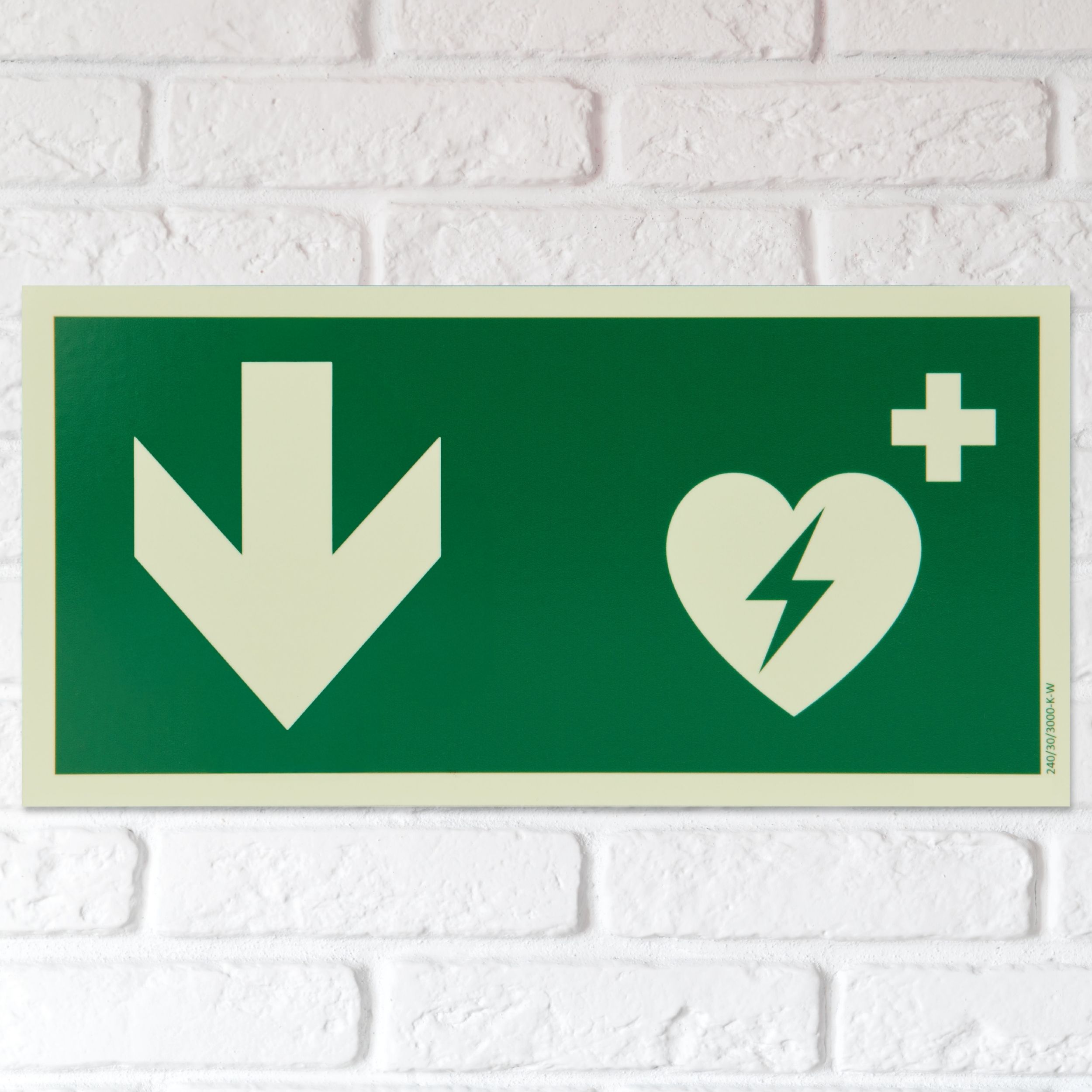 defibrillator aed hinweisschild mit pfeil nach unten bzw hinten langnachleuchtend beispiel