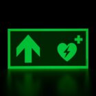 defibrillator aed hinweisschild mit pfeil nach vorne bzw oben photolumineszierend, langnachleuchtend leuchtend