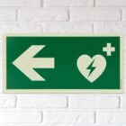 defibrillator hinweisschild mit pfeil nach links langnachleuchtend wand
