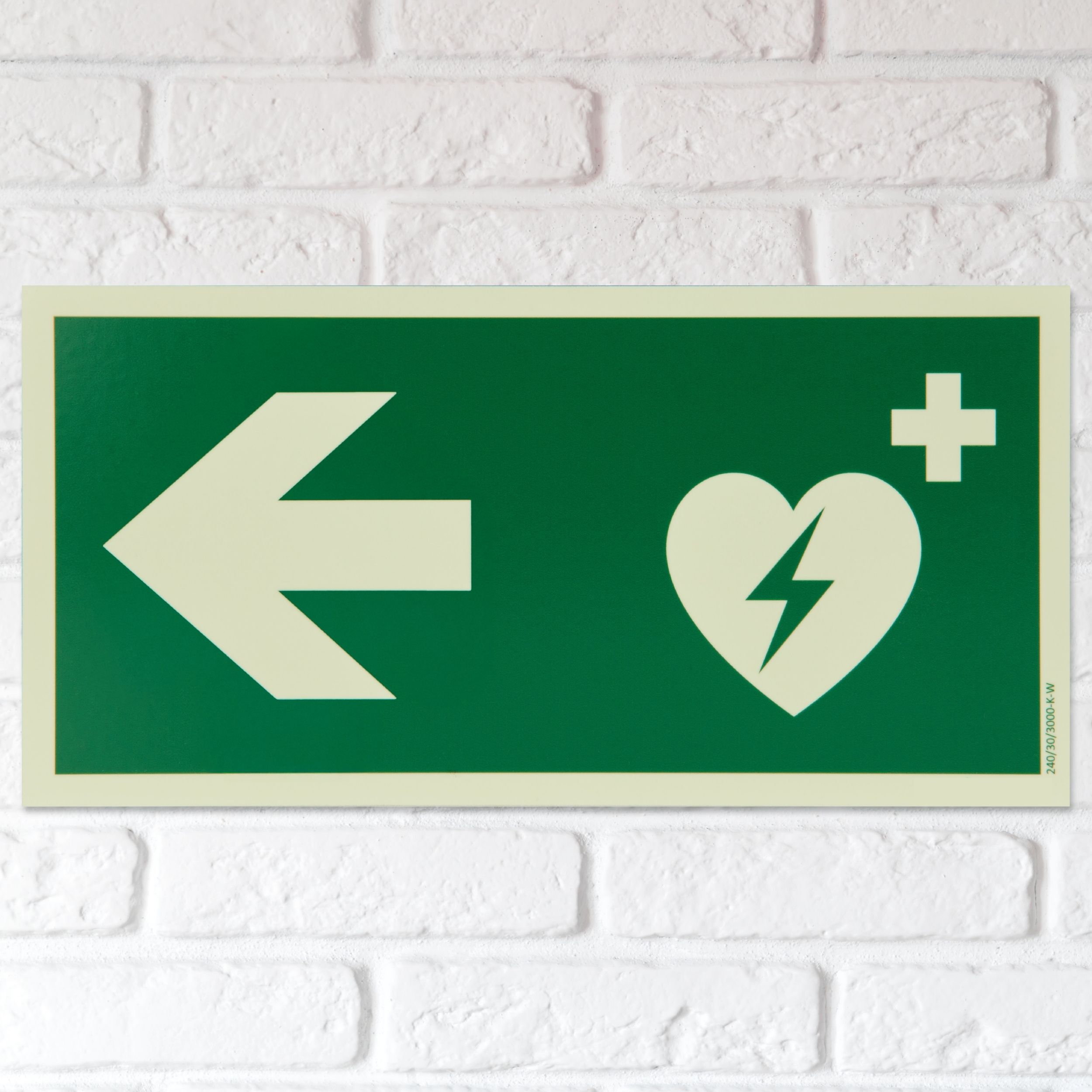 defibrillator hinweisschild mit pfeil nach links langnachleuchtend wand